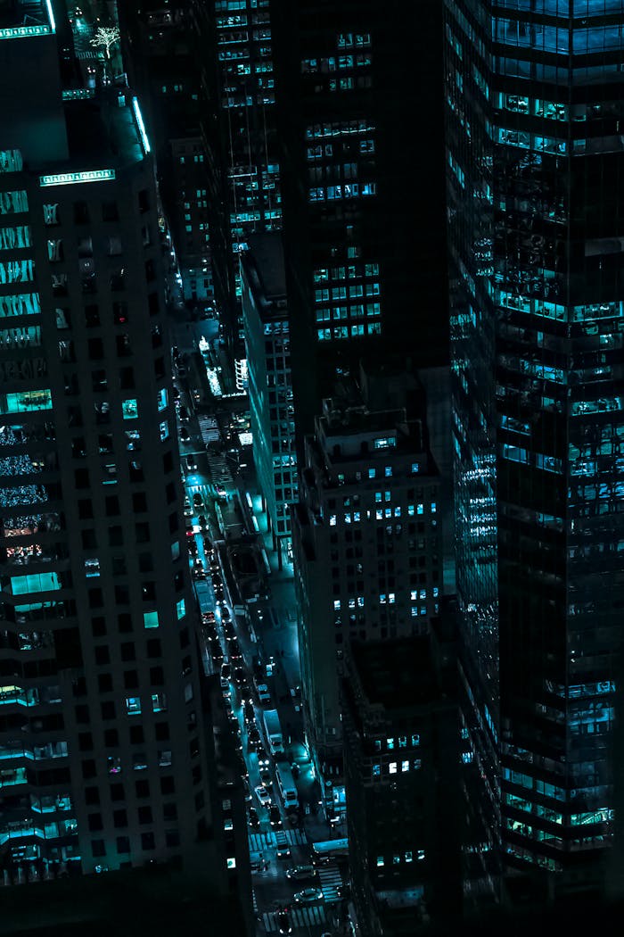Dla Firm Captivating aerial view of illuminated skyscrapers in New York City during the night.