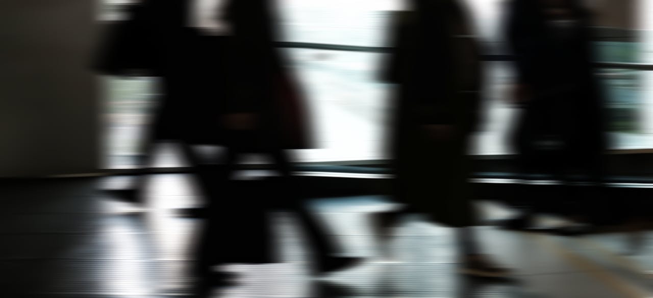 Strona główna Abstract blurred motion of people walking indoors, depicting urban life and busy routines.