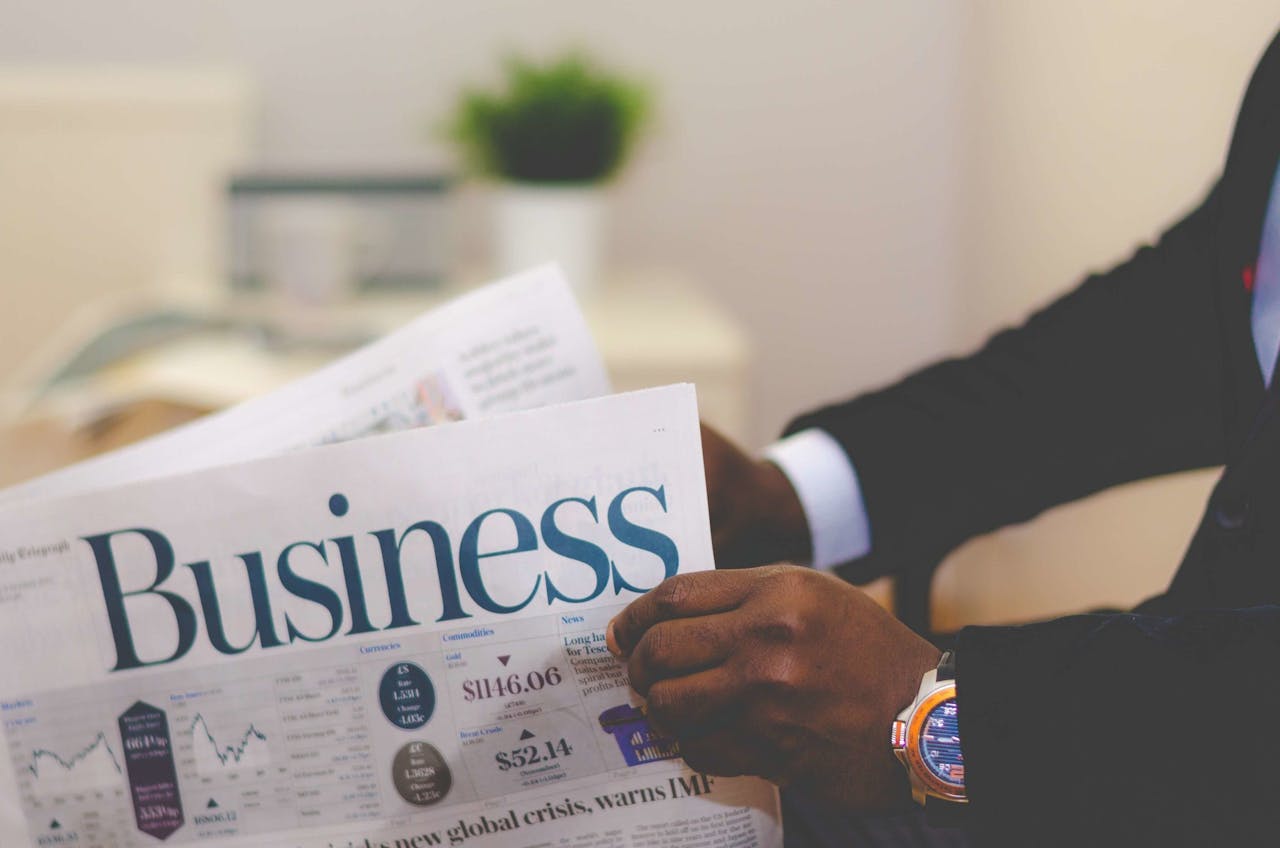 Dla Firm Close-up of a businessman reading a newspaper indoors, focusing on business headlines.